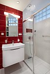 Sprchový kout je oddělen od zbytku koupelny skleněnou posuvnou stěnou